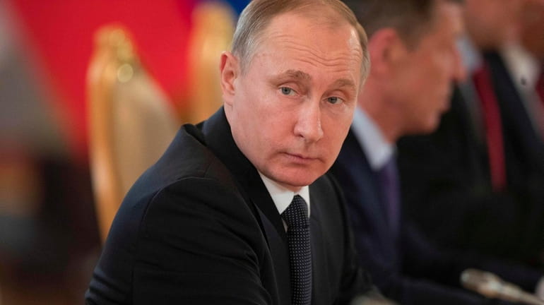 Russian President Vladimir Putin listens to his Uzbek counterpart during...