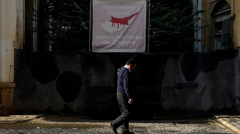 A man walks across the U.N buffer zone in front...