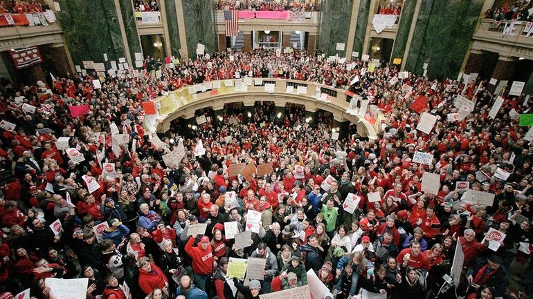 A crowd fills the Wisconsin Capitol rotunda on the fifth...