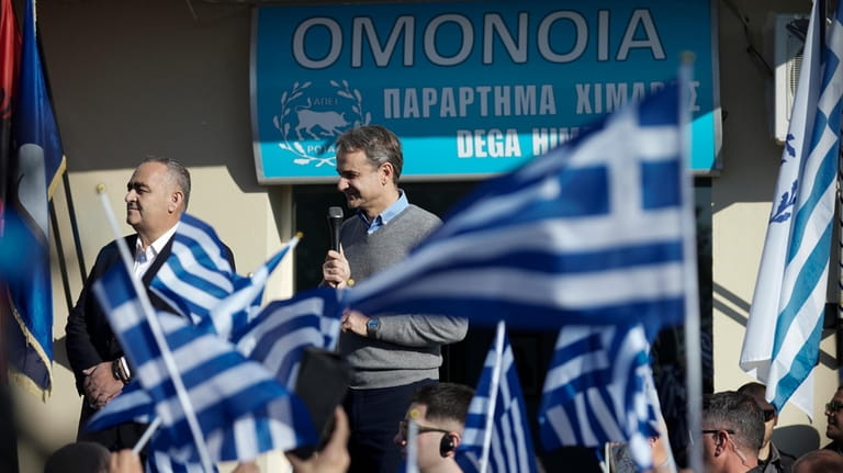 Greek Prime Minister Kyriakos Mitsotakis speaks next to Fredis Beleris,...