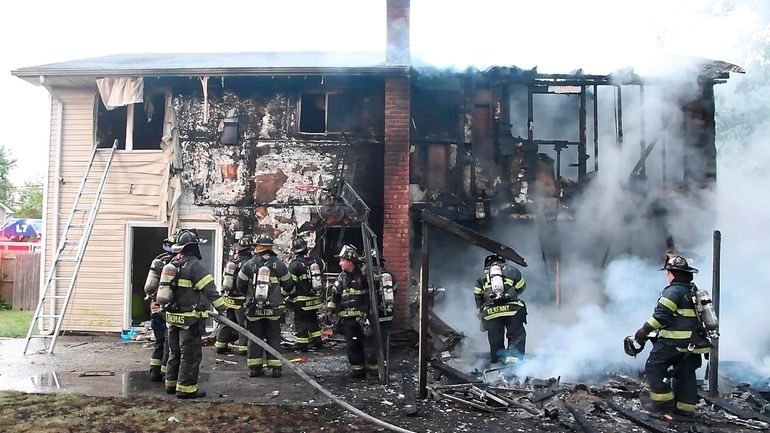 Islip firefighters at a house fire on Les Street that...