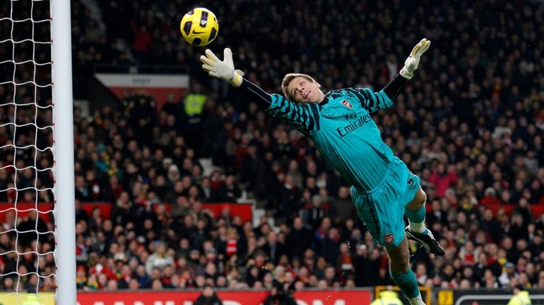 Arsenal goalkeeper Wojciech Szczesny watches a header from Manchester United's...