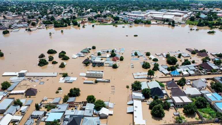 Houses are partially submerged following a dam collapse in Maiduguri,...