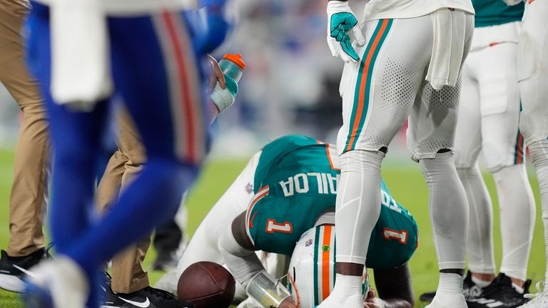 Miami Dolphins quarterback Tua Tagovailoa (1) is assisted on the...