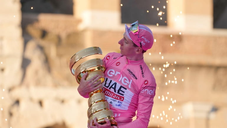 Tour of Italy winner Slovenia's Tadej Pogacar holds the trophy...