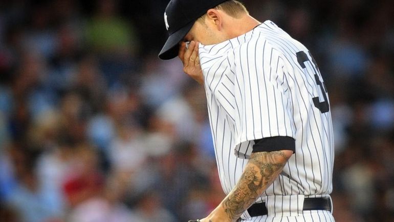 New York Yankees pitcher A.J. Burnett wipes his face after...