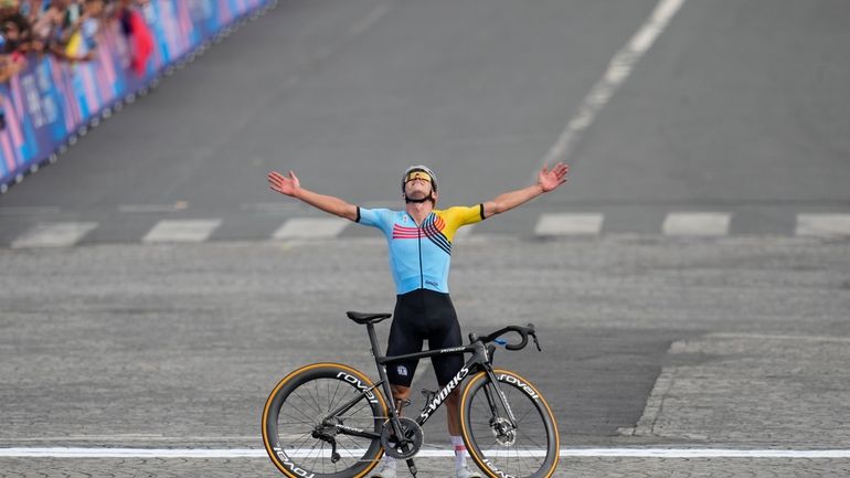 Remco Evenepoel, of Belgium, celebrates winning the men's road cycling...