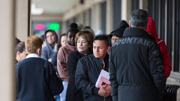 People wait in line outside the Medford Department of Motor...