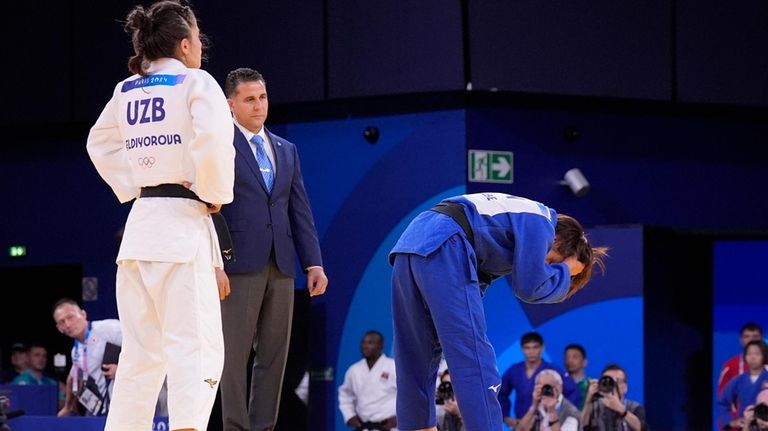 Japan's Uta Abe, right, reacts after the women -52 kg...