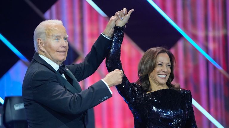 President Joe Biden, left, holds up the arm of Democratic...