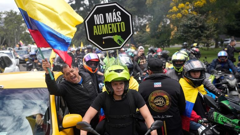 Motorcycle riders hold a caravan to protest the increase in...