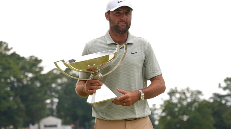 Scottie Scheffler poses with the FedExCup Trophy after the final...