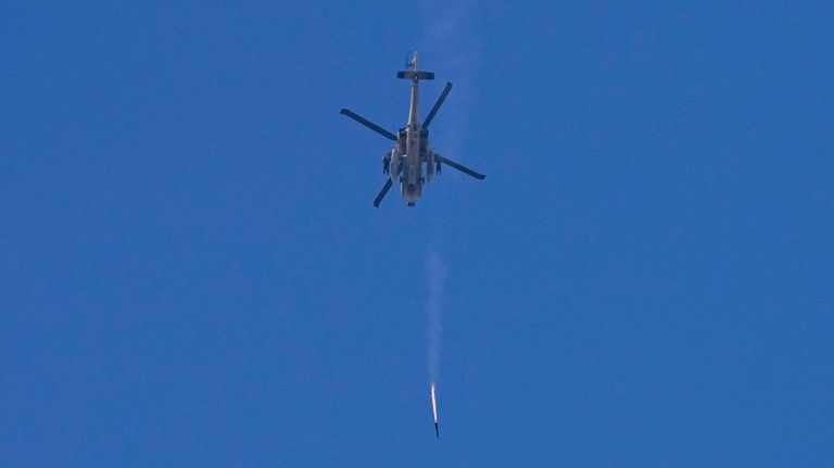 An Israeli Apache helicopter fires a missile in direction of...