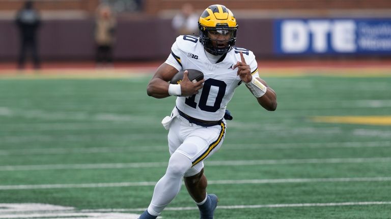 Michigan quarterback Alex Orji runs for a touchdown during the...