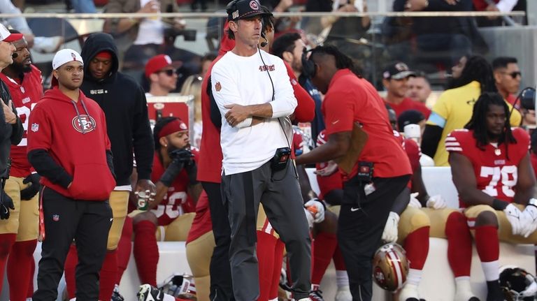 San Francisco 49ers head coach Kyle Shanahan, middle, watches from...