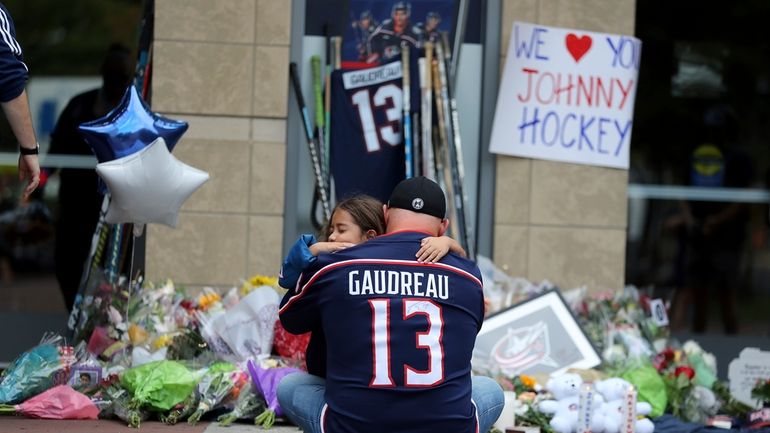 Shiloh Rivera, facing, mourns with Hylas Stemen of Columbus, at...