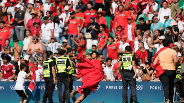 Invaders run on the pitch during the men's Group B...