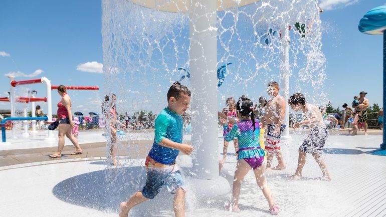 Joshua DiLeo, of Deer Park, cools off in the spray park...