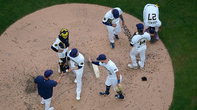 Milwaukee Brewers' Dallas Keuchel (60) hands the ball to manager...