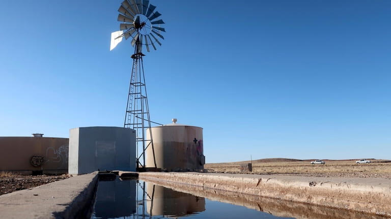 A windmill draws water for livestock in Leupp, Ariz., on...