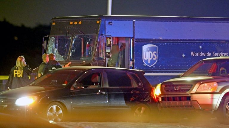 Law enforcement stand near a vehicle that appears to be...