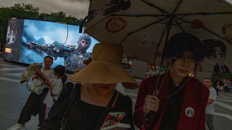 People walk past an advertisement promoting the latest blockbuster new...