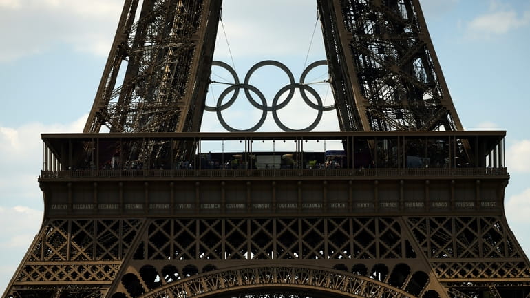 The Olympic rings are seen on the Eiffel Tower from...