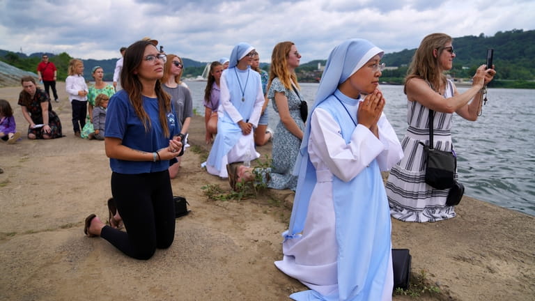 Sister Mary Fatima Pham, second from right, kneels with her...