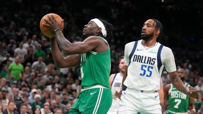 Boston Celtics guard Jrue Holiday, left, takes a shot at...