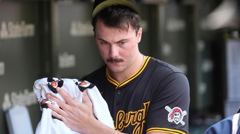 Pittsburgh Pirates starting pitcher Paul Skenes walks through the dugout...