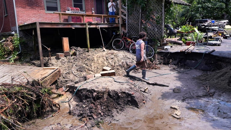 August Thompson walks over the washed out remains of the...