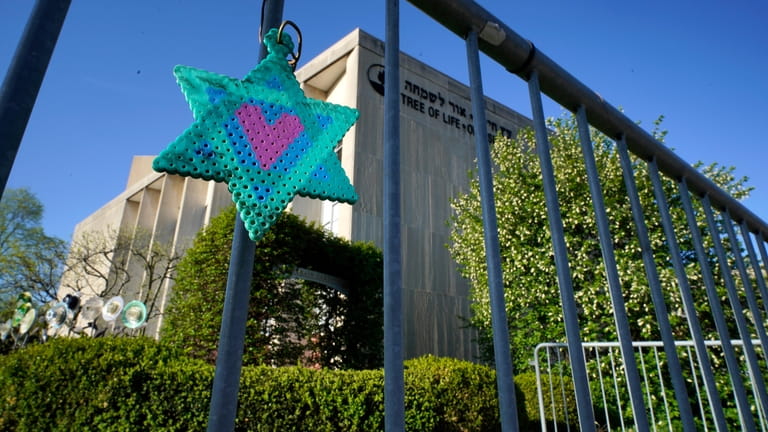 A Star of David hangs from a fence outside the...