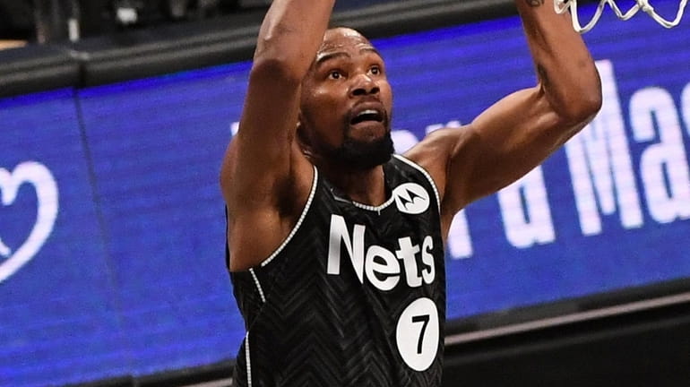 Nets forward Kevin Durant goes up for a dunk against...