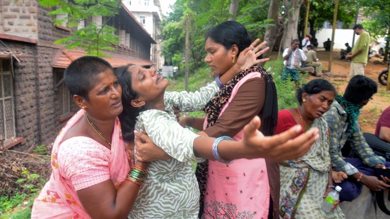 Leela Devi, center, with her arms outstretched, wails after hearing...