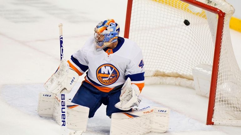 Islanders goaltender Semyon Varlamov looks on as a puck hit...