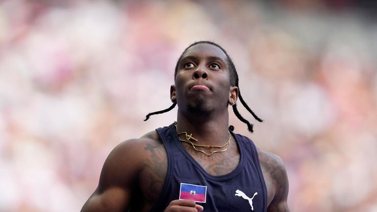 Christopher Borzor, of Haiti, reacts after qualifying in a men's...