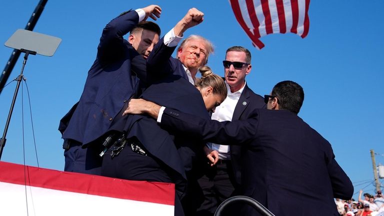 Republican presidential candidate former President Donald Trump is surrounded by...