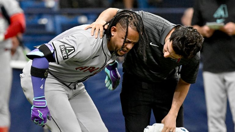 Arizona Diamondbacks Ketel Marte, left, is helped after being injured...