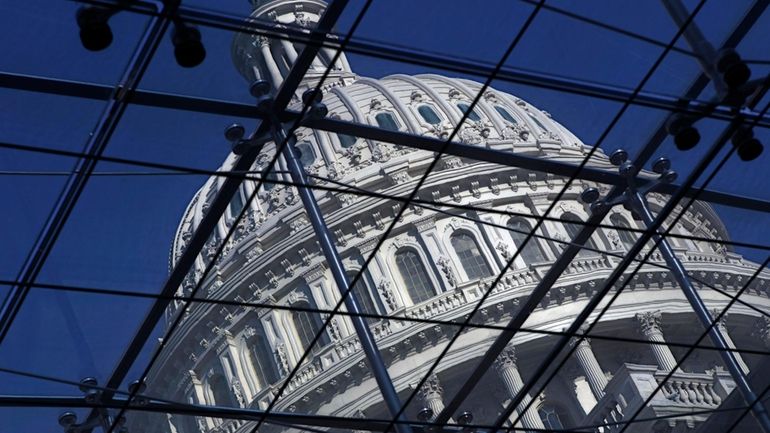 The Capitol dome on Capitol Hill is seen through a...