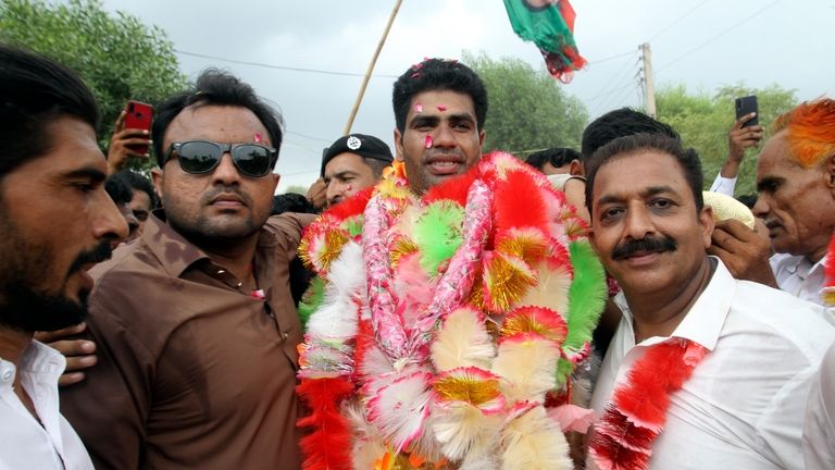 Pakistan's javelin gold medalist, Arshad Nadeem, center, is greeted by...