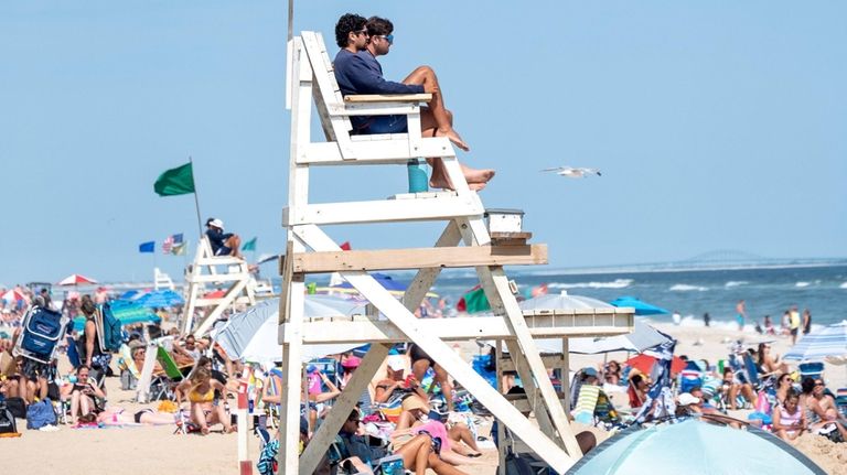 Lifeguards watch bathers Friday at Tobay Beach.