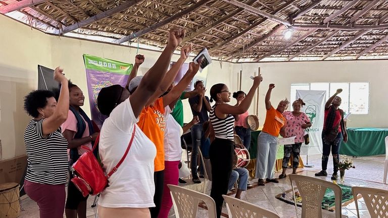 Members of the National Confederation of Rural Women (CONAMUCA) sing...