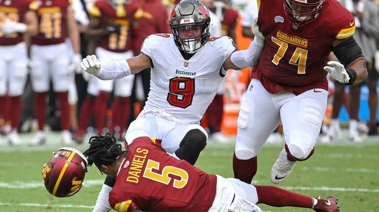 Washington Commanders quarterback Jayden Daniels (5) loses his helmet as...