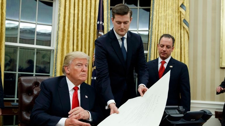 White House Staff Secretary Rob Porter, center, with President Donald...