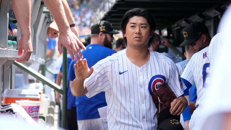Chicago Cubs pitcher Shota Imanaga is greeted in the dugout...
