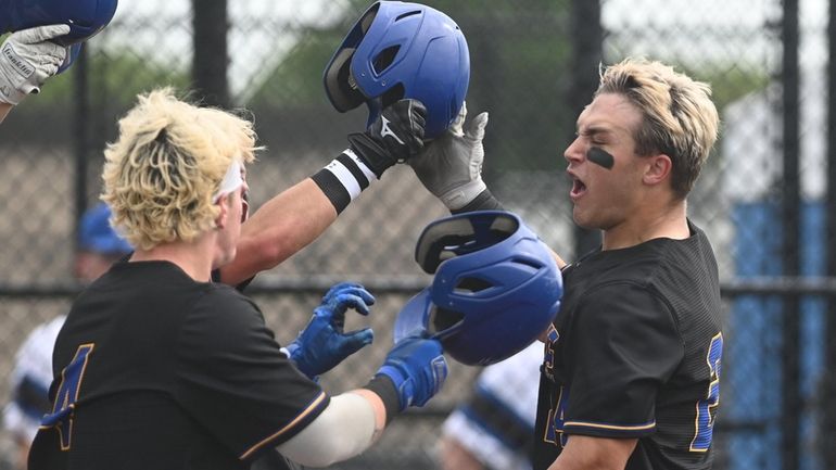 Matt Nowlan #24 of Comsewogue, right, gets congratulated after hitting...