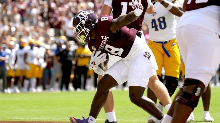 Texas A&M running back Le'Veon Moss (8) reacts after scoring...