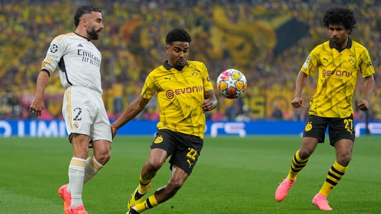 Real Madrid's Dani Carvajal challenges for the ball with Dortmund's...