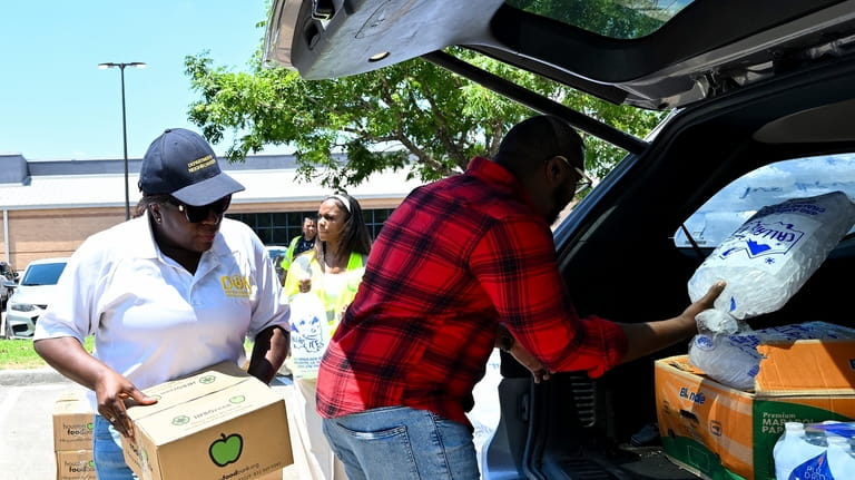 Volunteers help to hand out ice and supplies at Acres...