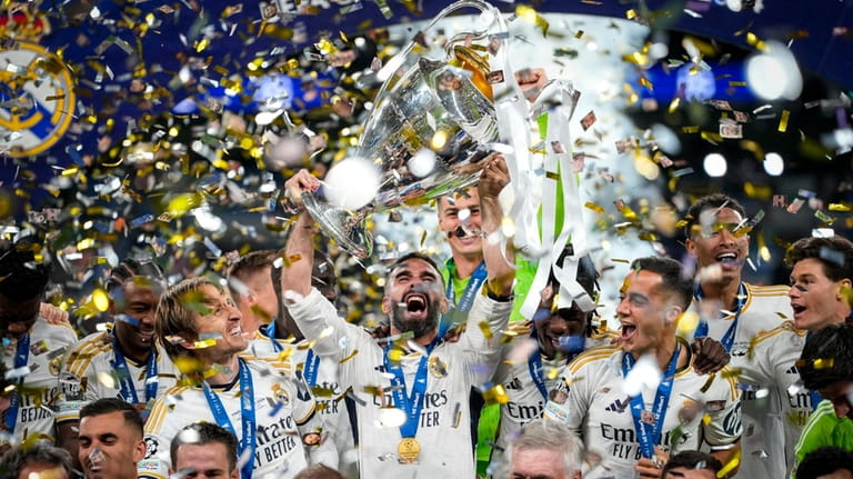 Real Madrid's players celebrate with the trophy after winning the...